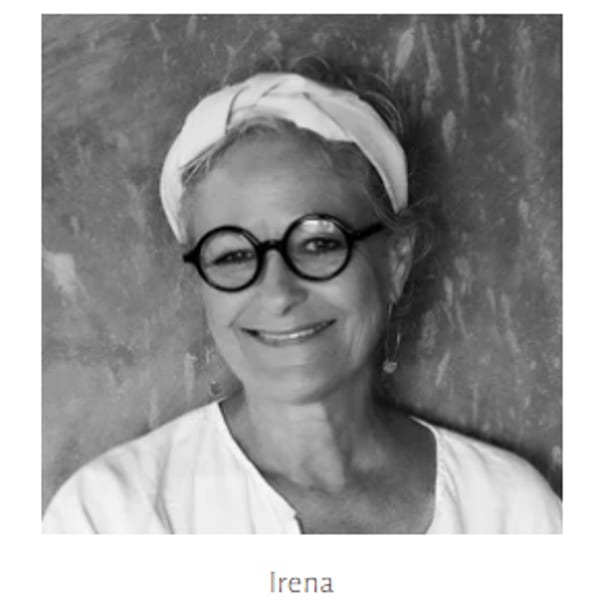 Black and white portrait of a smiling woman, Irena, wearing round glasses and a headscarf.